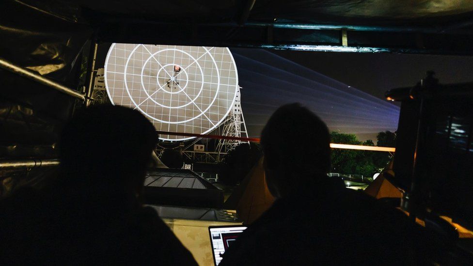 A projection team test the light show on the Lovell radio telescope