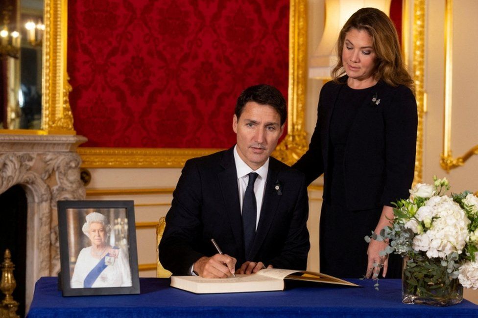 Canadian Prime Minister Justin Trudeau and his wife Sophie Trudeau sign a book of condolence at Lancaster House in London on 17 September